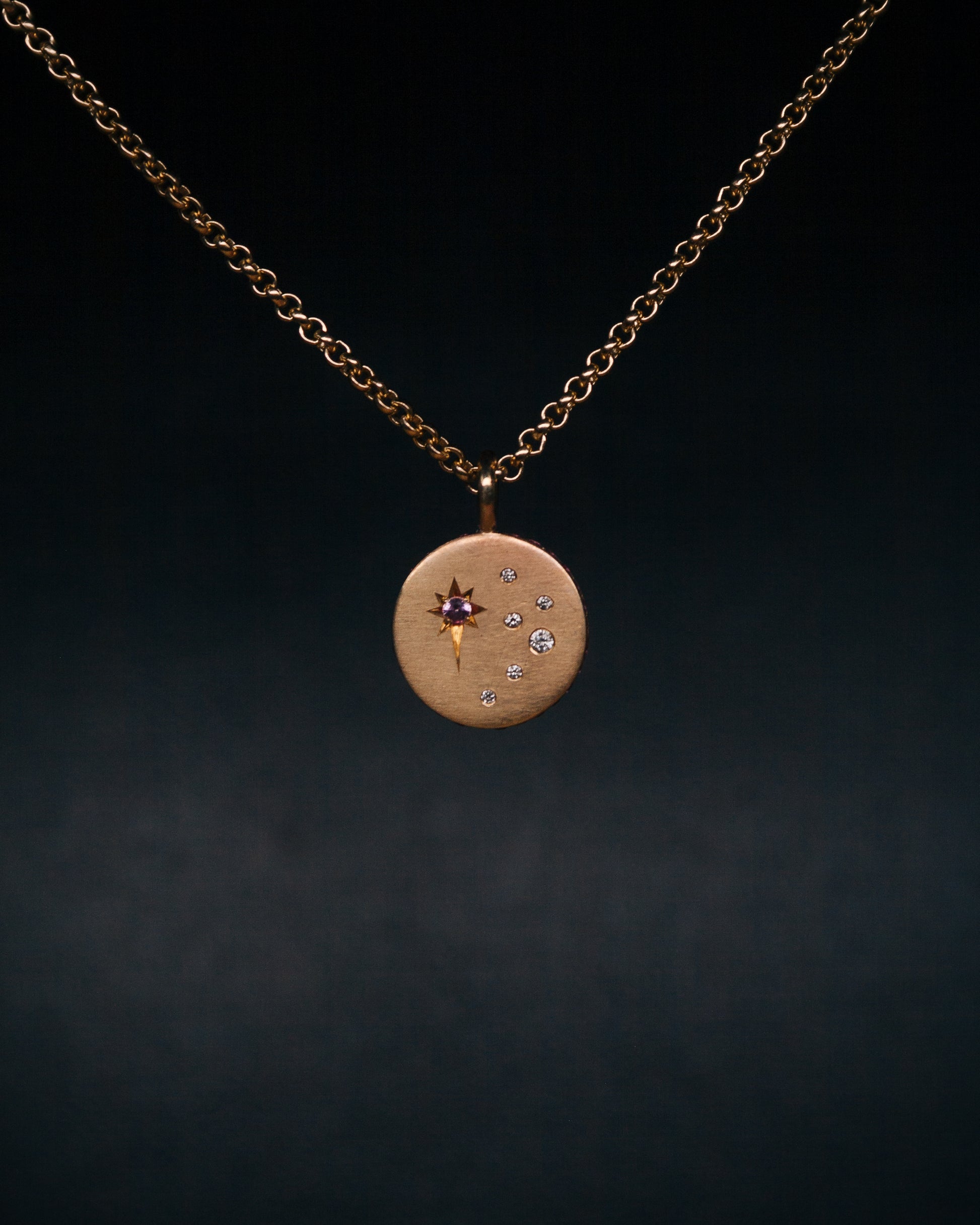 round gold disc sapphire pendant on a chain