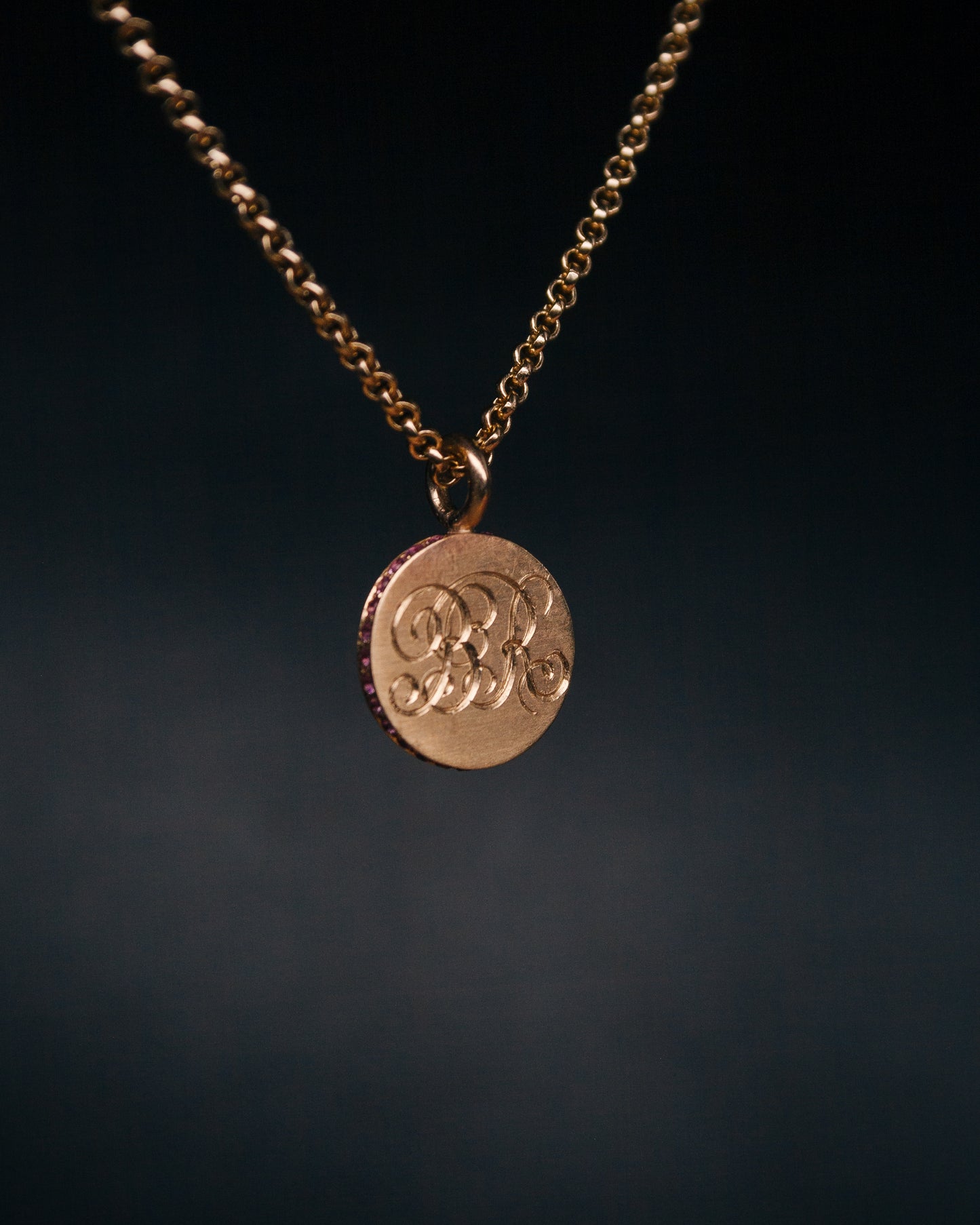 round gold disc sapphire pendant with engraving on a chain